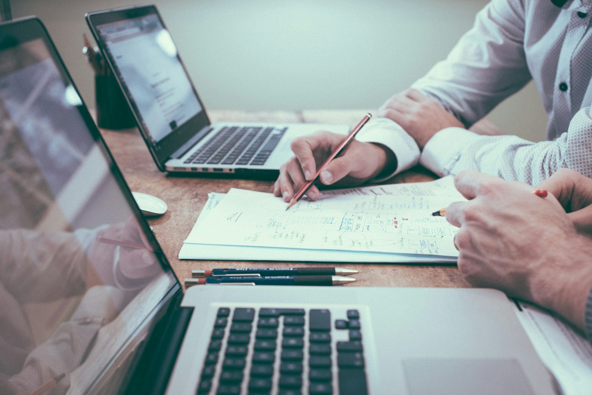 Arbeitsplatz mit Unterlagen und Laptop für Recherche zu Finanzthemen